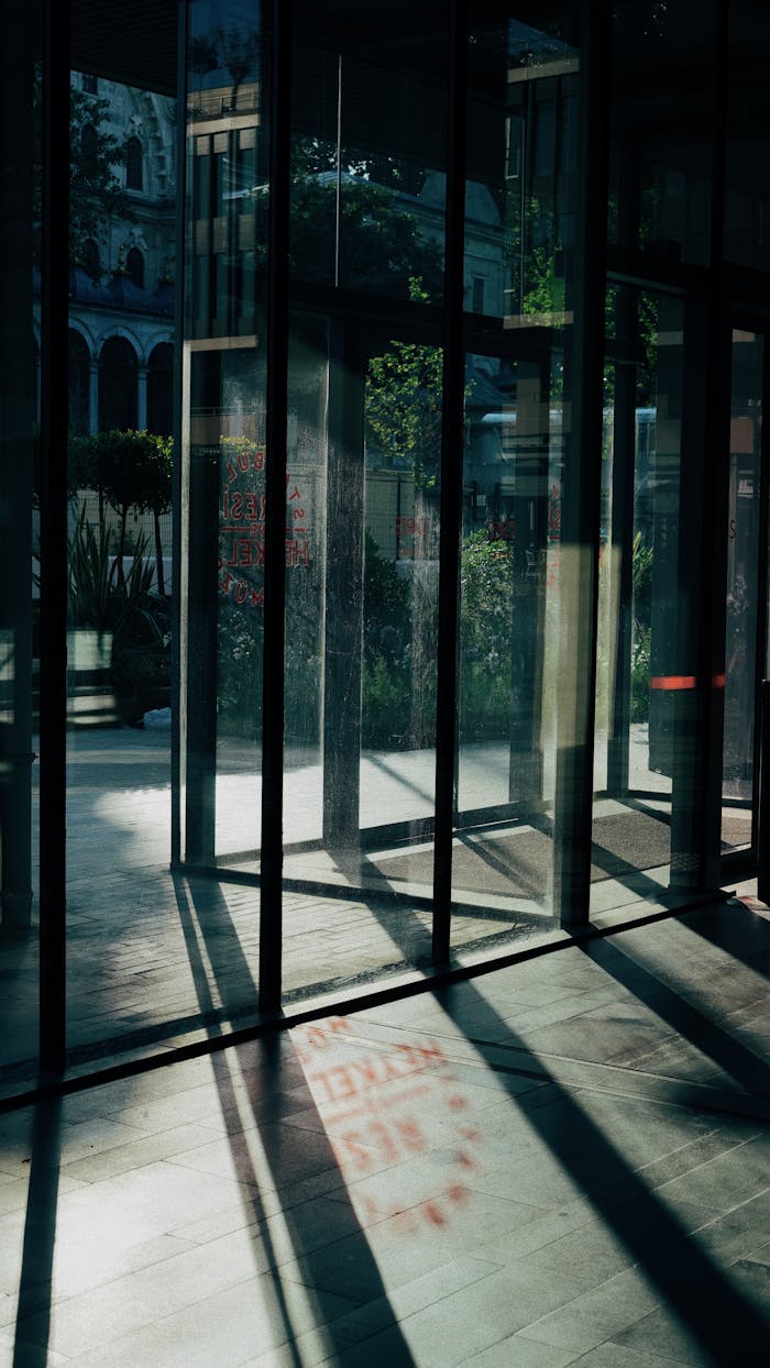 about-us-01 Glass doors casting shadows in Istanbul, capturing modern architecture and a hint of the city's historic charm.
