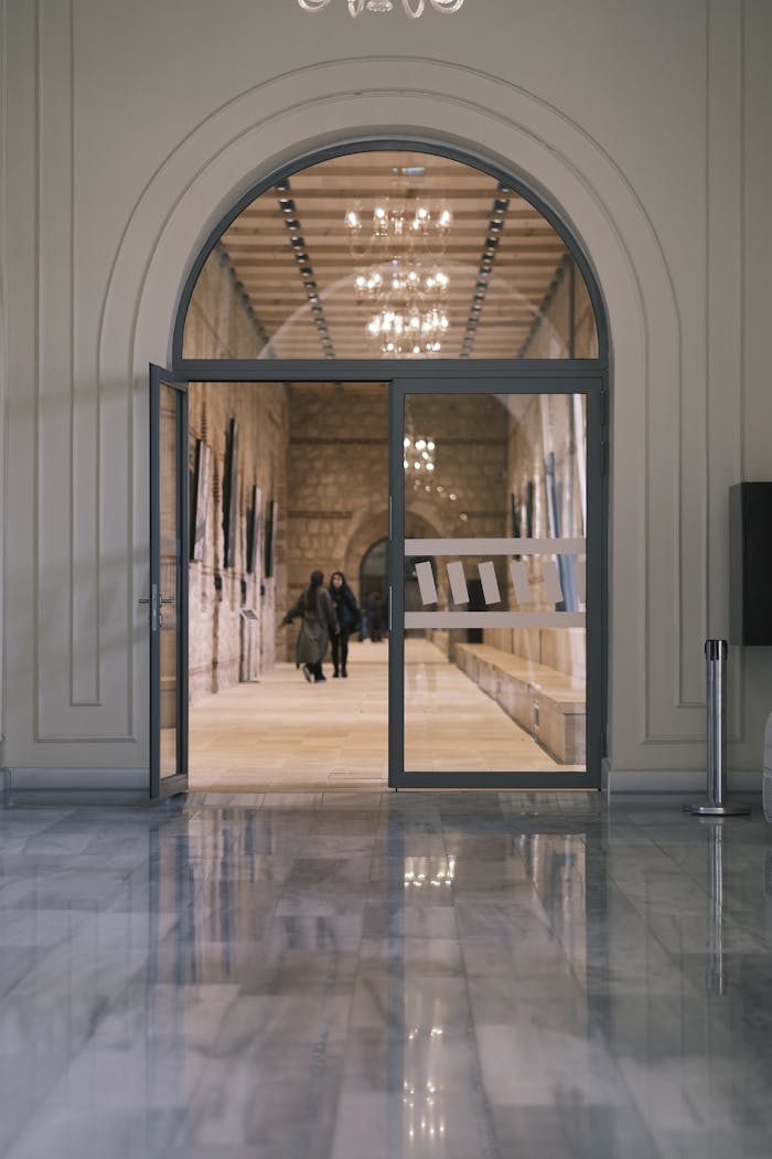 The Art of Drawing Readers In: Your attractive post title goes here Elegant interior view of a corridor with an open glass door and people walking inside.