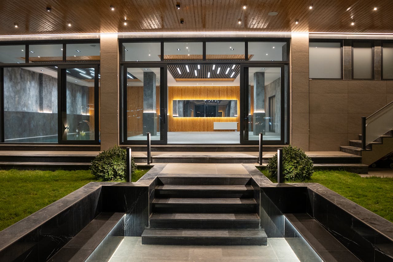 Crafting Captivating Headlines: Your awesome post title goes here Elegant illuminated entrance to a modern luxury house at night with landscaped garden.