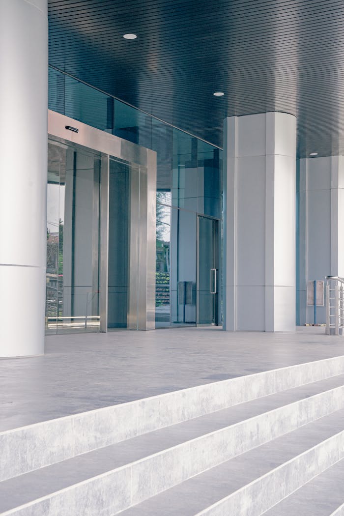 Elegant modern building entrance featuring sleek glass and steel architecture with a minimalist design.